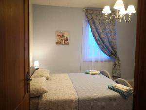 um quarto com uma cama e uma janela em Appartamento vacanze Assisi nel cuore em Costano