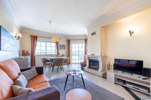 a living room with a couch and a fireplace at Apartment Presa de Moura in Carvoeiro