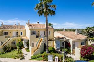 a large house with a palm tree in front of it at Apartment Presa de Moura in Carvoeiro