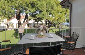 a table and chairs on a balcony with trees at Appartamento Romantica 35 in Raffa
