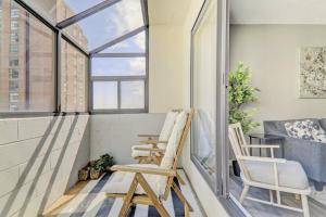 a balcony with two chairs and a window at Roomy Top Floor at Stampede w Free Parking and AC in Calgary