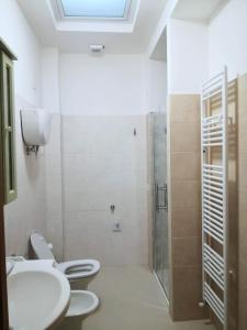 uma casa de banho com 2 WC e um chuveiro em Appartamento vacanze Assisi nel cuore em Costano