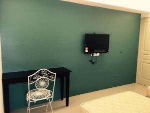 a room with a table and a chair and a tv at Lavender house IPOH in Ipoh