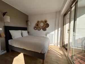 1 dormitorio con cama y espejo en la pared en Résidence de l'Hermitage, T2 avec Parking, en Le Touquet-Paris-Plage