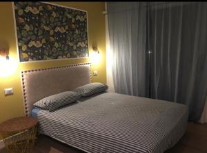 Un dormitorio con una cama con una pintura encima. en Guest house Festinalente en Montegrotto Terme