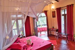 a bedroom with a pink bed with a pink canopy at Sri Lancashire Guest House in Bentota