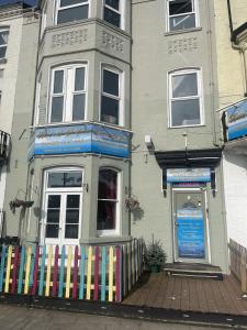 ein Haus mit einem bunten Zaun davor in der Unterkunft Henrys on the Prom in Great Yarmouth