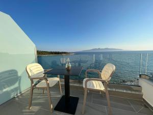 a table and chairs on a balcony with a view of the water at Sea Breeze Villa in Sarandë