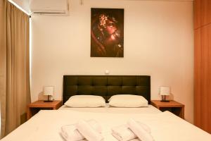 a bedroom with a bed with a painting on the wall at Thessaloniki Center Modern Apartment in Thessaloniki