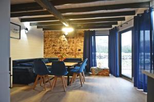 a dining room with a table and blue chairs at Ale Jazz w cenie jacuzzi i basen in Nowe Miasto