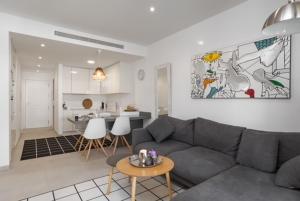a living room with a gray couch and a kitchen at Viente Cien in San Javier
