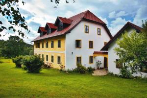 une grande maison blanche avec un toit rouge dans l'établissement Farma Mošna, à Zbytiny