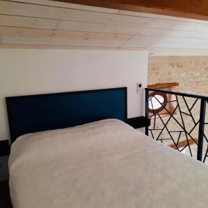 a bedroom with a bed with a blue head board at Le Cabanon des Lavandes entre Mont Ventoux et Luberon in Sault-de-Vaucluse
