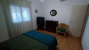 1 dormitorio con cama, espejo y silla en DEPARTAMENTO DIARIO PASEO DEL JOCKEY, en Córdoba