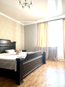een slaapkamer met een groot bed en een kroonluchter bij 458 Рядом Байтерек с кондиционером 2 большими кроватями и раскладным диваном для компании 1-6 человек in Astana