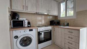a kitchen with a washing machine and a microwave at Cozy apartment in Nea Smyrni in Athens