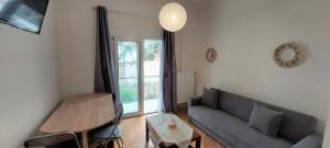uma sala de estar com um sofá e uma mesa em Cozy apartment in Nea Smyrni em Atenas