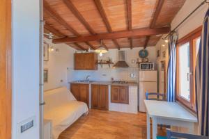 a small kitchen with wooden cabinets and a table at Capo Bianco Studio by HelloElba in Portoferraio