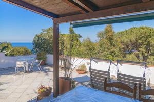 a patio with a table and chairs and a view of the ocean at Capo Bianco Studio by HelloElba in Portoferraio
