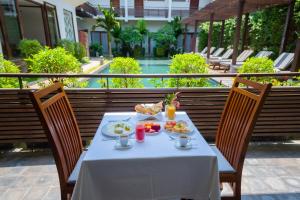 einen Tisch mit Speisen und Getränken auf dem Balkon in der Unterkunft Siemreap Vasinh Residence in Siem Reap