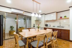 uma cozinha com uma mesa de madeira e cadeiras em City white beach house2 Hua Hin em Hua Hin