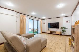 sala de estar con sofá y TV de pantalla plana en City white beach house2 Hua Hin, en Hua Hin