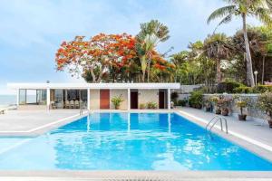 a swimming pool in front of a house at City white beach house2 Hua Hin in Hua Hin
