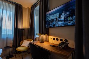 Habitación de hotel con TV en la pared en Locanda Moderna Carlambroeus en Montevecchia