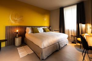 1 dormitorio con 1 cama grande y pared amarilla en Locanda Moderna Carlambroeus en Montevecchia