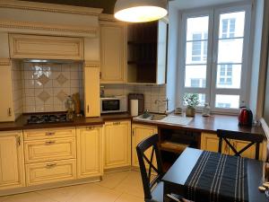 uma cozinha com armários amarelos e uma mesa em Poznańska Street Apartment em Varósvia