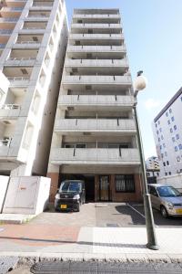 un parcheggio di fronte a un edificio alto di 長期歓迎 地下鉄豊水すすきの駅 歩いてスグ IK Minami 6 Jo Residence 603 IK南6条レジデンス a Sapporo