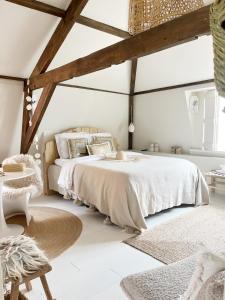 ein Schlafzimmer mit einem großen Bett und einem Tisch in der Unterkunft Het sfeerhuis aan zee in Vlissingen
