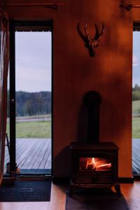 a fireplace in a room with a view of a field at Stodoła naturalnie - dom z balią na Kaszubach in Brodnica