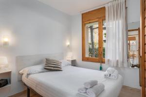 1 dormitorio con 1 cama con toallas en Apartamentos CASA MAREA La Fosca parking y piscina, en Palamós