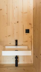 un lavabo blanco en una pared de madera en Slow Cabin - Sint-Truiden, en Sint-Truiden