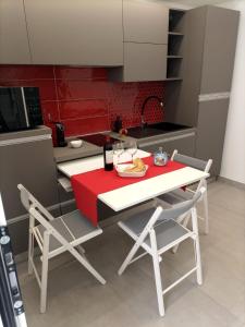 a kitchen with a table and two chairs and a red table at Sikelia Apartments in Pozzallo