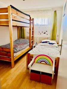 1 Schlafzimmer mit 2 Etagenbetten und einem Regenbogenstuhl in der Unterkunft Haus Vogelsand Whg 307 in Cuxhaven