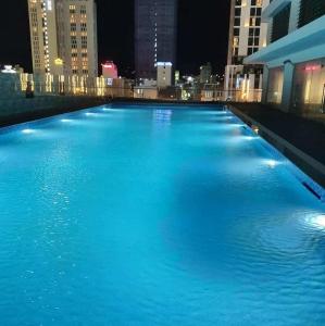 uma grande piscina de água azul em uma cidade à noite em ST Apartment - FLC SeaTower Quy Nhon em Quy Nhon