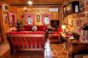 a living room with wooden walls and red furniture at Kuca za odmor klet Šaban in Šiljakovina