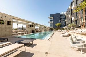 une piscine avec des chaises longues et un bâtiment dans l'établissement Hollywood 1br w pool gym nr Santa Monica Blvd LAX-906, à Los Angeles
