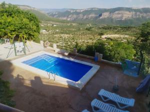 una vista aérea de una piscina con sillas y montañas en El Tejo Yeste y Mirador del Segura en Yeste