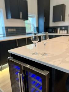 two wine glasses sitting on a counter in a kitchen at Stunning modern 2 bedroom, 2 bathroom townhouse in Cheltenham