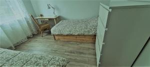a bedroom with two beds and a wooden floor at Apartament Przy Parku w Orłowie in Gdynia