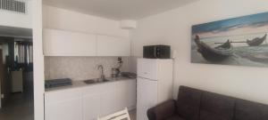 a kitchen with a sink and a refrigerator and a couch at Yona balev in Eilat