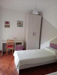 um quarto com uma cama, uma secretária e um armário em Appartamento Marianna em Piazza Armerina