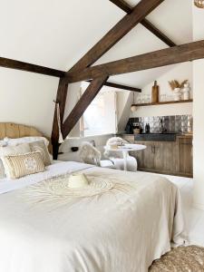a bedroom with a large white bed and a table at Het sfeerhuis aan zee in Vlissingen