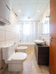 a white bathroom with a toilet and a sink at Apartamento Luz in L'Escala