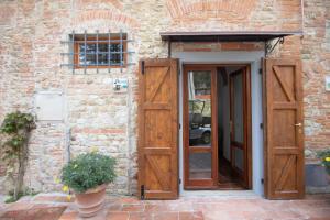 una entrada a un edificio de ladrillo con puertas de madera en Agriturismo Poggio Nardini en San Donato a Livizzano
