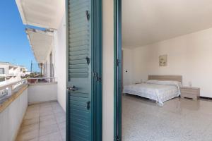 uma porta para um quarto com uma cama na varanda em Angela House by BarbarHouse em Melendugno