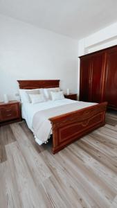 a bedroom with a large bed with a wooden headboard at Piso BOIRO PLAYA Robustiano in Boiro